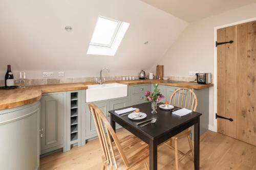 a kitchen with a table and chairs and a sink at The Roost in Biddlestone