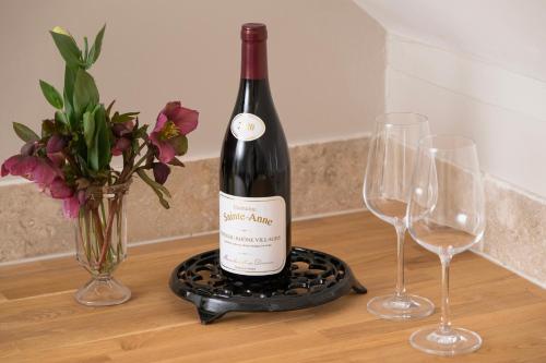 a bottle of wine sitting on a table with two wine glasses at The Roost in Biddlestone