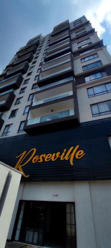 a tall building with a sign on the side of it at Rosëville Budget Studio -- Rooftop Pool, Gym, Office Space, Children play area in Nairobi