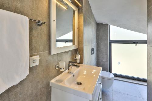 a bathroom with a sink and a toilet and a mirror at Serin Villas in İslâmlar