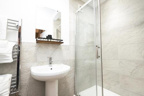 a bathroom with a sink and a glass shower at Rooms at The Dressers Arms in Chorley