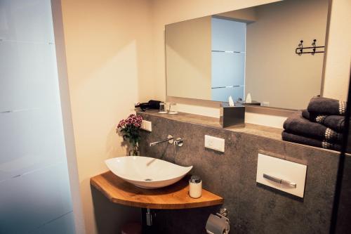 a bathroom with a sink and a mirror at Gästezimmer im FamilienWeingut Räder in Hillesheim