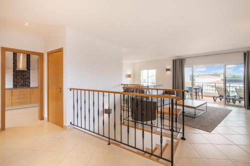a living room with a staircase and a dining room at NAU Salema Beach Village in Salema