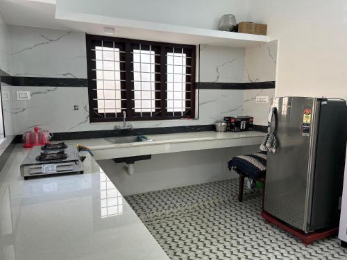 a kitchen with a stainless steel refrigerator and a sink at Devas Homestay in Kallar-Bridge