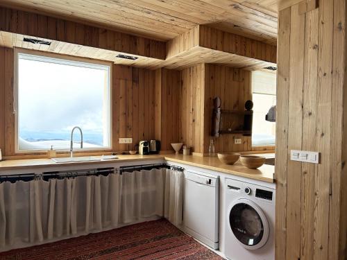a kitchen with a sink and a washing machine at Nevada suites Dúplex con vistas y acceso a pista in Sierra Nevada