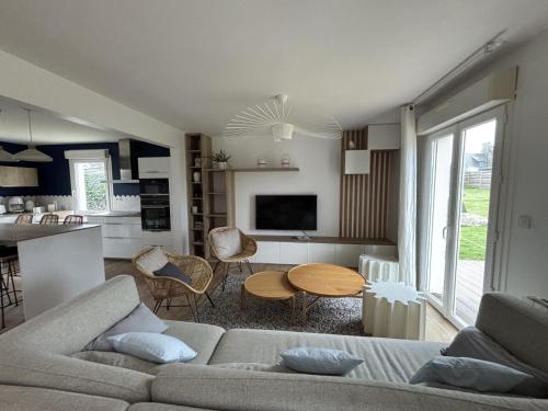 un salon avec un canapé et une table dans l'établissement La maison de landrellec, à Pleumeur-Bodou