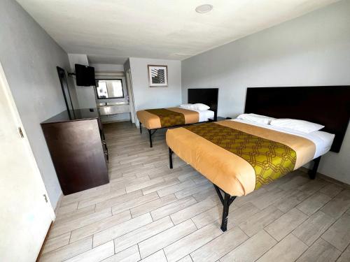 ein Hotelzimmer mit zwei Betten und einem Fernseher in der Unterkunft Budget Inn Motel in San Antonio