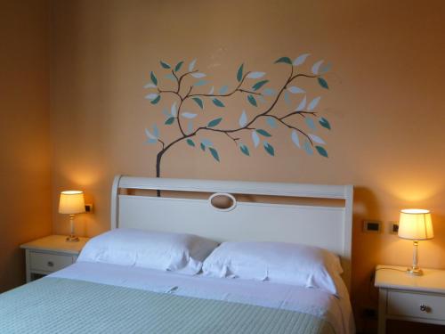 a bedroom with a bed with a tree sticker on the wall at Locanda Fuoriporta in Cantagrillo