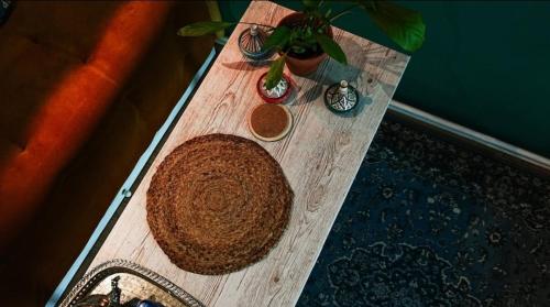 a wooden table with a plant and two vases on it at Atlas room with shared bathroom in Bratislava