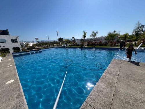 a young girl is standing in front of a swimming pool at Casa Monstera Bahia in Naranjo