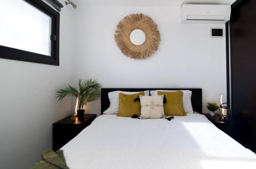 a bedroom with a bed with yellow pillows and a mirror at Vistamar in Patalavaca