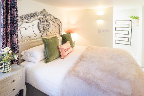 a bedroom with a white bed with green pillows at Gorgeous Boutique Flat Sleeps 2 in Lyme Regis in Lyme Regis