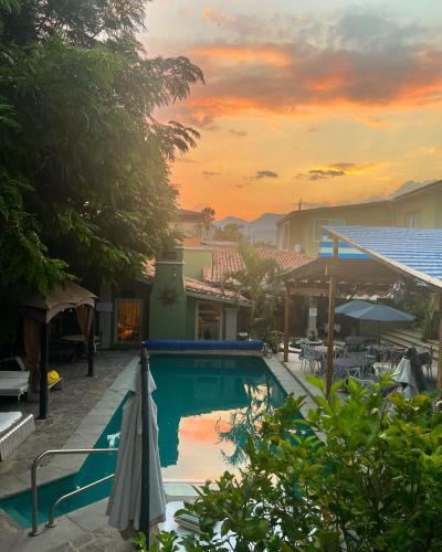 a swimming pool with an umbrella next to a house at Hacienda del Lago Boutique Hotel in Ajijic
