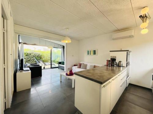 une cuisine et un salon avec un canapé et une table dans l'établissement Appartement Solane 23 Lumio, à Lumio