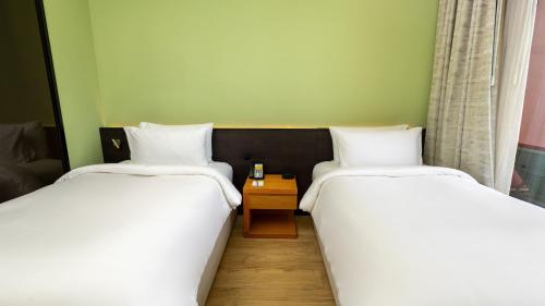 two beds sitting next to each other in a room at voco Dubai Monaco, the Heart of Europe by IHG in Dubai