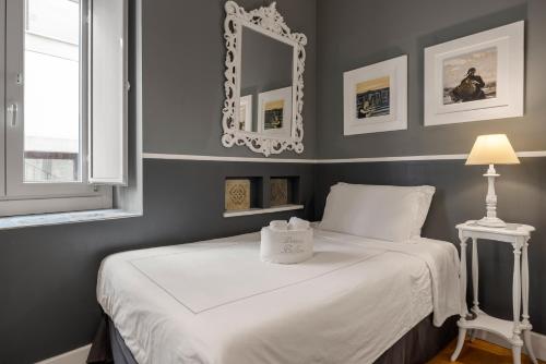 a bedroom with a bed with a mirror on the wall at Dimora Bellini - Residenza d'Epoca in Palermo