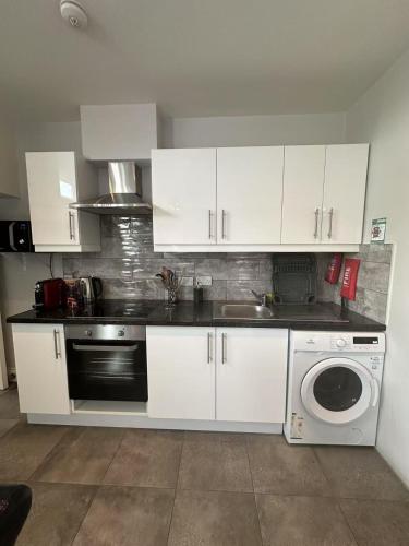 a kitchen with white cabinets and a sink and a dishwasher at Abbey Apartments in Dublin