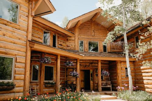 a log cabin with flowers in front of it at Bentwood Inn in Wilson