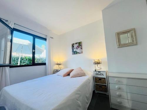 une chambre avec un lit blanc et une fenêtre dans l'établissement Appartement Solane 23 Lumio, à Lumio