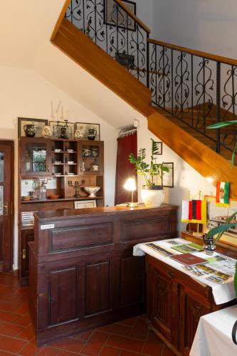 a room with a wooden counter and a staircase at Vár Vendéglő Panzió in Sárospatak