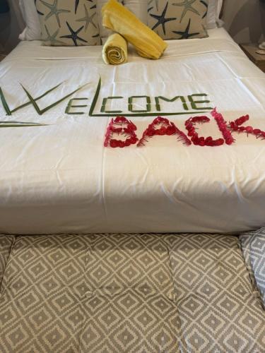a white bed with a sign that says lane cut at Casa Doro Villa in Glacis