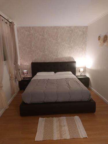 a bedroom with a large bed and two night stands at Hotel airport in Merville