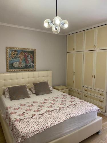 a bedroom with a bed and a painting on the wall at Himara City-Center Apartment in Himare