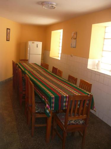 a room with a table with chairs and a refrigerator at El Tuco Hotel in Cusco