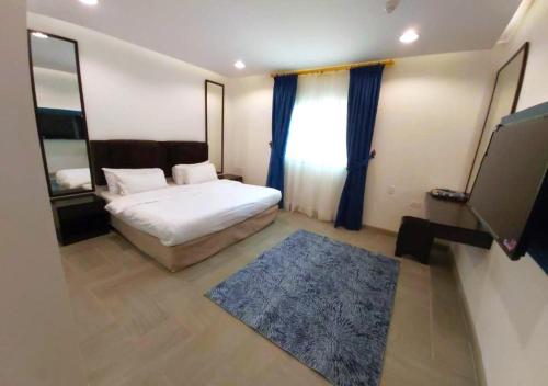 a bedroom with a bed and a blue rug at Sea Club Resort in Dammam