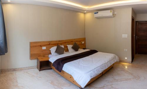 a bedroom with a large bed with a wooden headboard at Hotel Aghore Shaktipeeth in Narendranagar