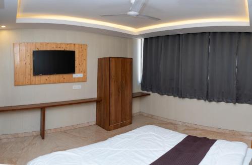 a bedroom with a bed and a flat screen tv at Hotel Aghore Shaktipeeth in Narendranagar