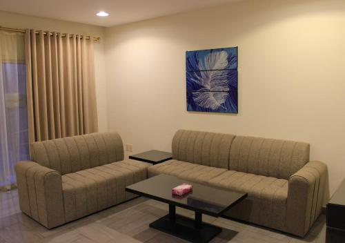 a living room with two couches and a table at Sea Club Resort in Dammam