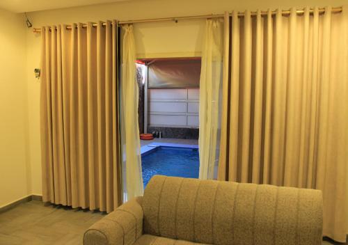 a living room with a couch and a pool at Sea Club Resort in Dammam