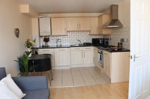 a kitchen with white cabinets and a stove top oven at Scandinavian City Centre Apartment in Worcester