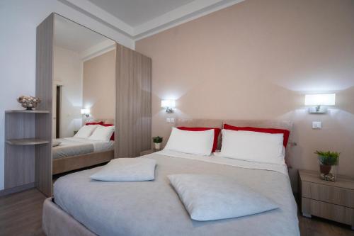 a bedroom with two beds with red and white pillows at Hotel Sammaritani in Rimini