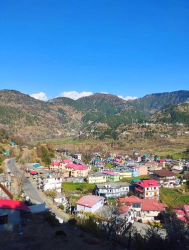 a small town in a valley with mountains in the background at Aditya Homestay Dalhousie in Dalhousie