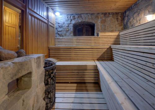 a sauna with wooden steps and a stone wall at Rezydencja nad Wodospadem Spa&Wellness koło Szklarskiej Poręby in Szklarska Poręba