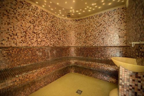 a tiled bathroom with a tub and a sink at Rezydencja nad Wodospadem Spa&Wellness koło Szklarskiej Poręby in Szklarska Poręba