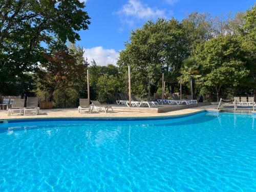 a large blue swimming pool with tables and chairs at Whaka Lodge in Seissan