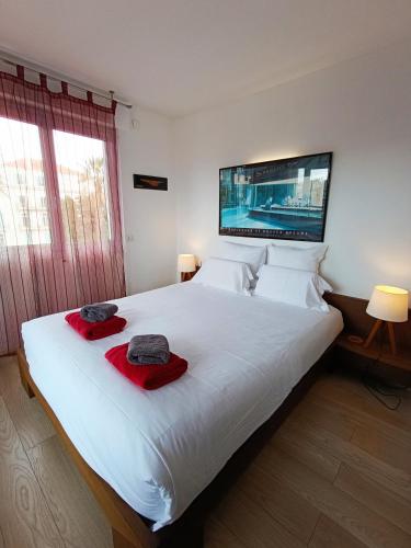 - une chambre avec un grand lit blanc et des serviettes rouges dans l'établissement Plages du Midi, Superbe Vue Mer, Grand Confort, 4 pers, à Cannes