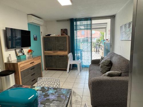 un salon avec un canapé et une table dans l'établissement Le Petit Bora-Marseillan Plage -Residence Bora Bora-400m plage d'honneur, à Marseillan