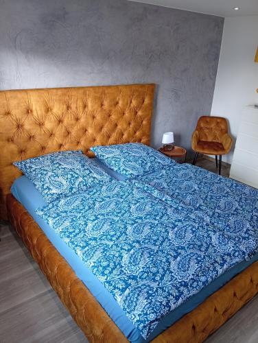 a large bed with a blue blanket on it at Ferienwohnung Ostfriesland in Stapelmoor
