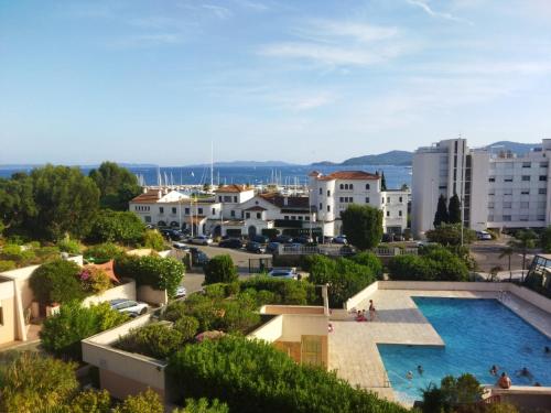 - une vue sur une ville avec une piscine et des bâtiments dans l'établissement Le Lavandou résidence les Mandariniers, au Lavandou