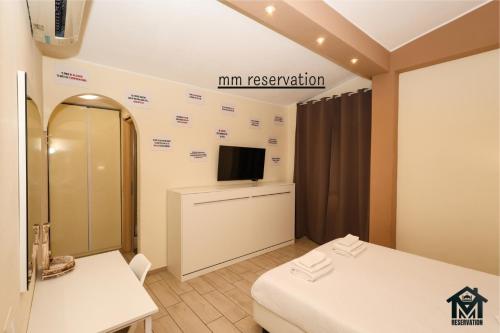 a room with two beds and a tv on the wall at Le Ghiande Appartamento Roma in Infernetto
