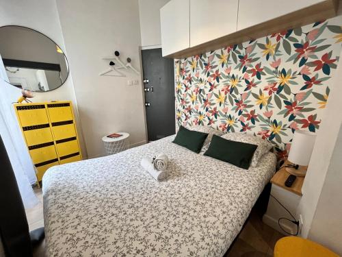 - une chambre dotée d'un lit avec un mur à motifs floraux dans l'établissement Le CoCon Nantais 2pers Wi-Fi TV, à Nantes