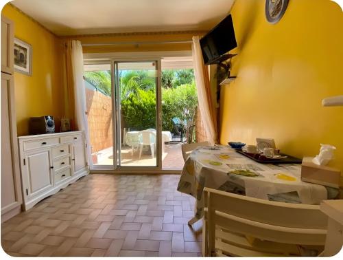 a dining room with a table and a sliding glass door at Cocon au Pradet Plage, terrasse & calme absolu in Le Pradet