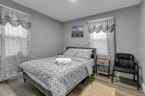 a bedroom with a bed and a black chair at Close to Niagara Fall Dream Home in Niagara Falls
