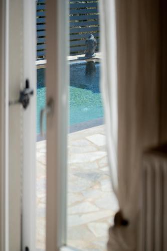 an open door with a view of a swimming pool at Bee Home by A&D Properties in Porto Rafti