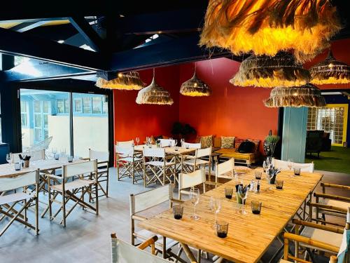 a dining room with tables and chairs and chandeliers at Whaka Lodge in Seissan