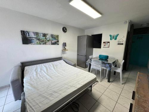 - une chambre avec un lit, une table et un réfrigérateur dans l'établissement Le Petit Bora-Marseillan Plage -Residence Bora Bora-400m plage d'honneur, à Marseillan